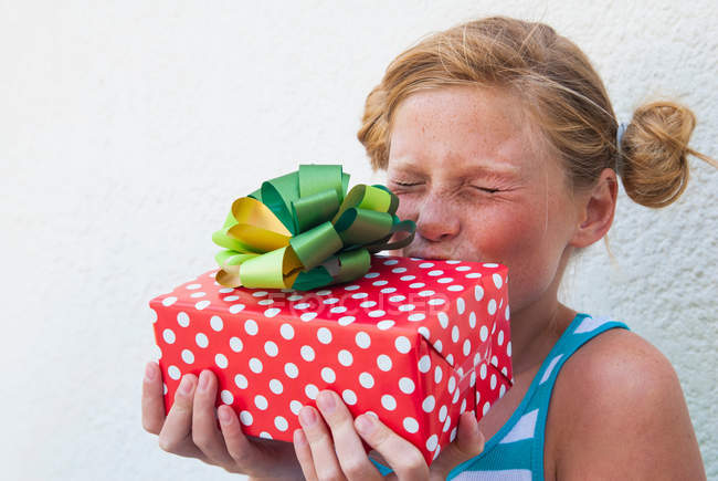 Девушка целует подарок в руке — стоковое фото