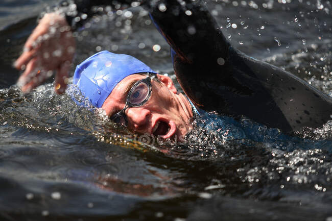 Триатлонист плавает в воде — стоковое фото