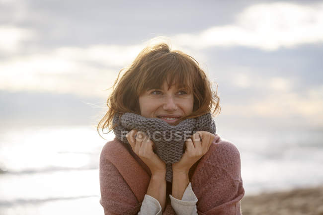 Frau mit Snood schaut lächelnd weg — Stockfoto