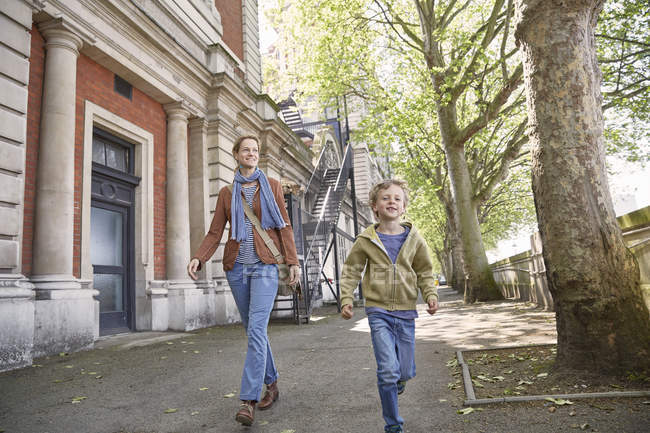 Caucasian mother and son walking on street together, London, UK — Stock Photo