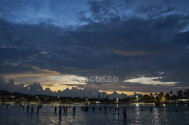 Силуэт толпы людей в море на восходе солнца, Алькудия, Майорка, Испания — стоковое фото