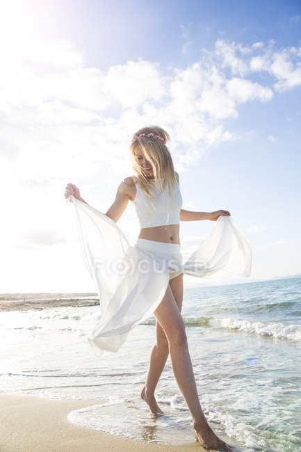 Junge Frau am Strand, tanzt und lächelt — Stockfoto