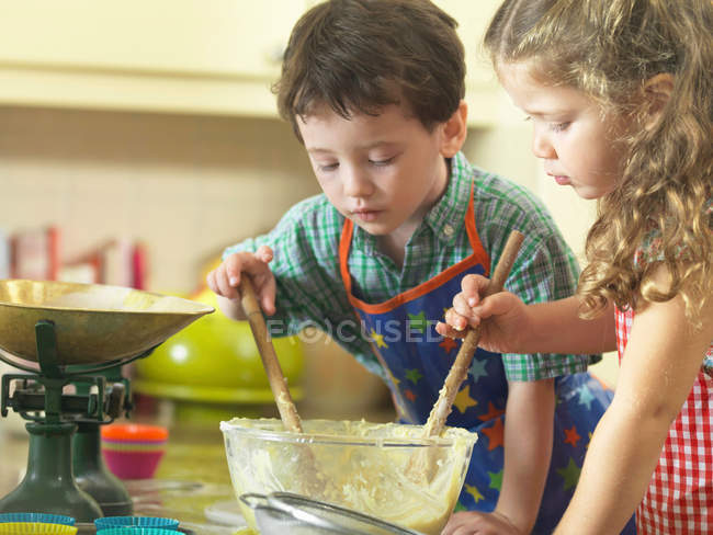 Дети вместе пекут на кухне — стоковое фото