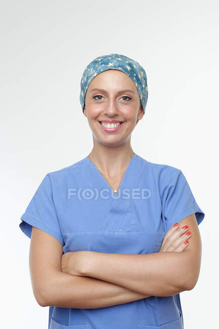 Cirujano con los brazos cruzados mirando a la cámara sonriendo - foto de stock