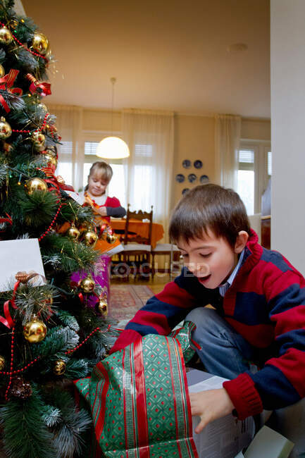 Мальчик рассматривает рождественские подарки — стоковое фото