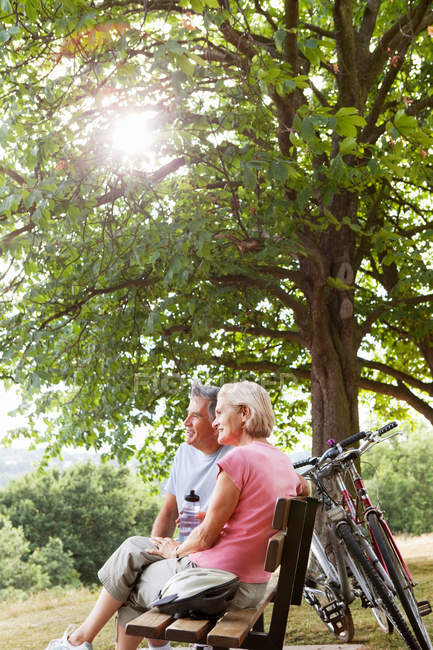 Couple faisant une pause sur le banc dans le parc — Photo de stock