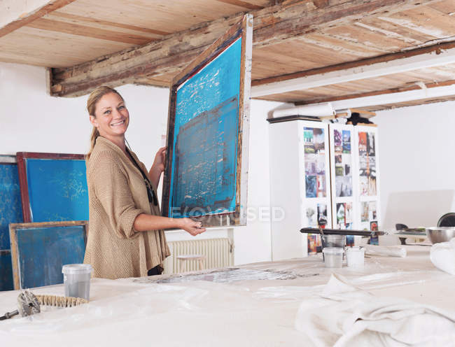 Designer with printing screen in studio — Stock Photo