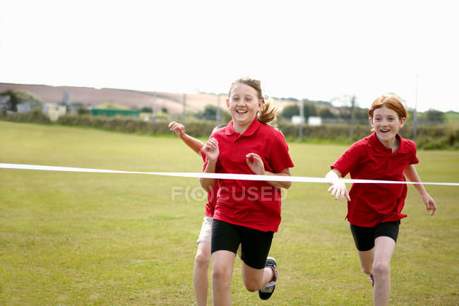 Chicas corriendo para cruzar la línea de meta, enfoque selectivo - foto de stock