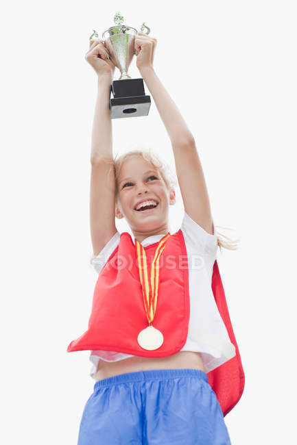Smiling girl holding trophy, focus on foreground — Stock Photo
