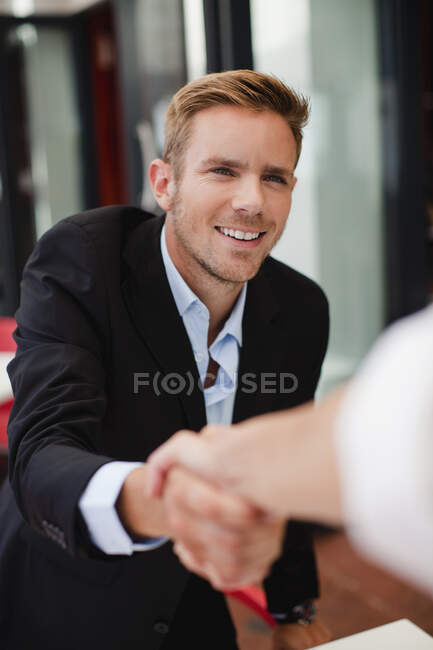 Geschäftsleute beim Händeschütteln am Tisch — Stockfoto