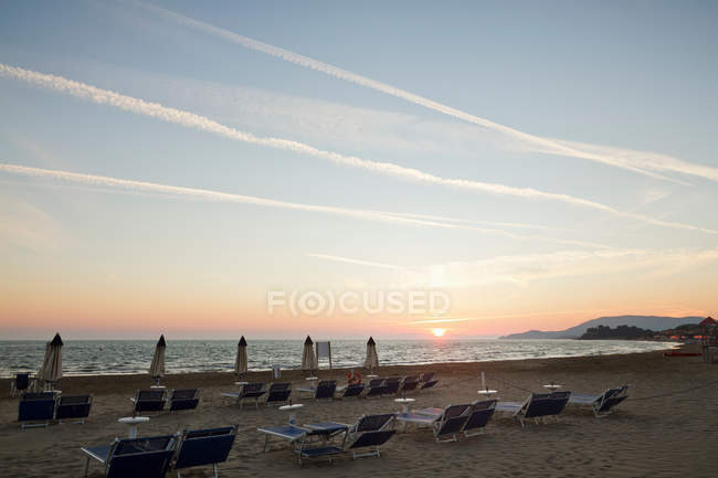 Chaises de pelouse en rangées sur la plage — Photo de stock