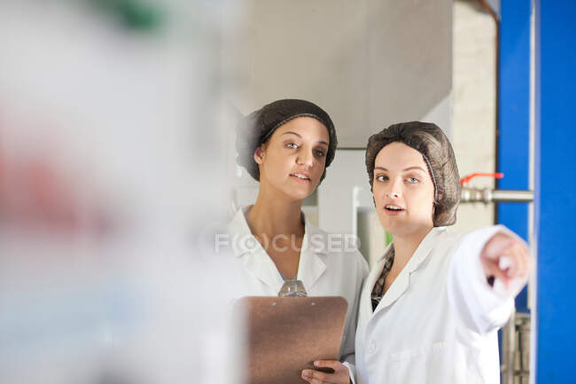 Dos mujeres que trabajan en una planta procesadora de aceitunas - foto de stock