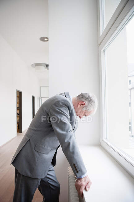 Homme d'affaires appuyé contre la fenêtre — Photo de stock