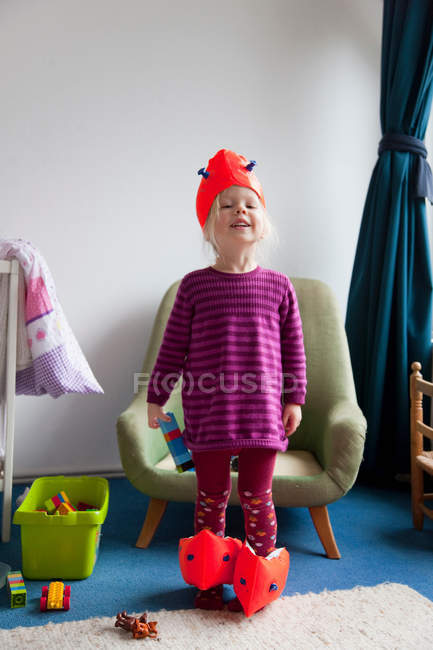 Menina brincando com asas de água dentro de casa — Fotografia de Stock