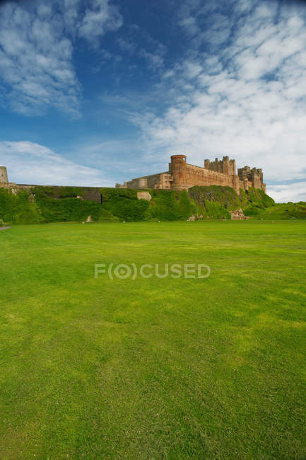 Castelo com gramado sob céu azul nublado — Fotografia de Stock