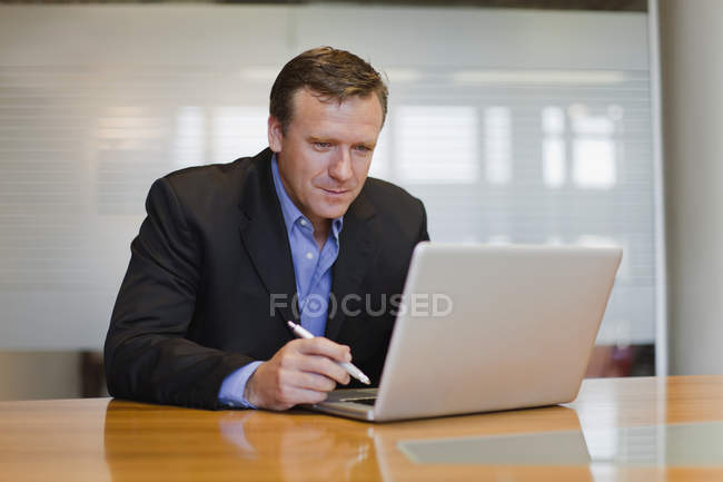 Бізнесмен працює на ноутбуці в офісі — стокове фото