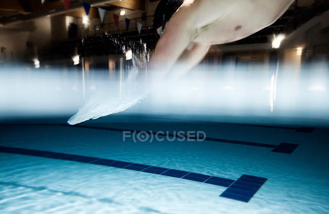 Homem esportivo pulando na piscina — Fotografia de Stock