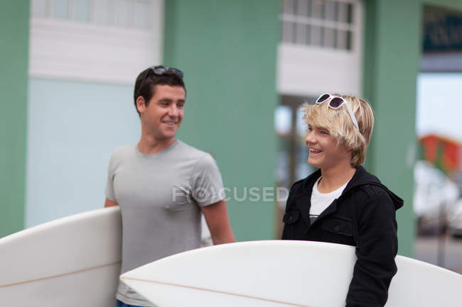 Teenage boys carrying surfboards — Stock Photo