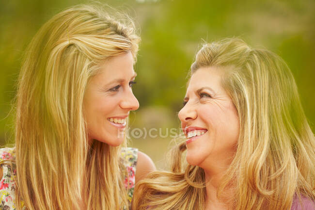 Madre e hija sonriéndose mutuamente - foto de stock