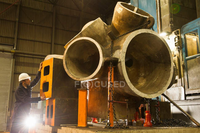 Worker using machinery in steel forge — Stock Photo