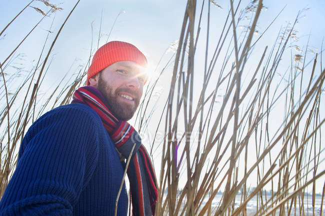 Smiling man standing in tall reeds — Stock Photo