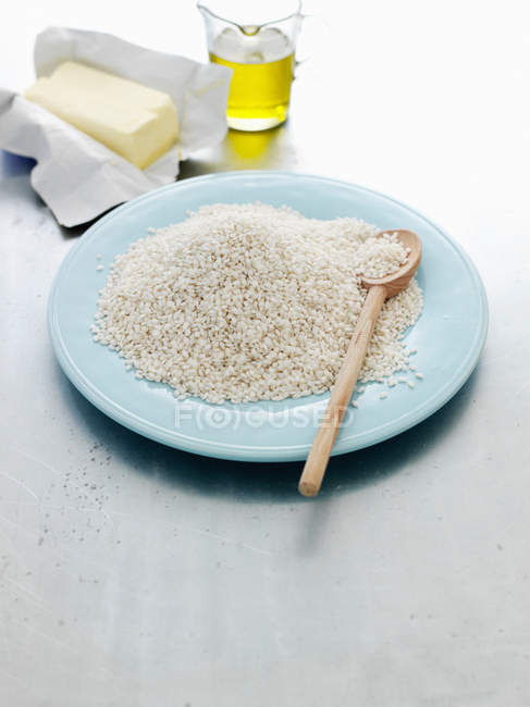 Placa de arroz risotto con cuchara de madera - foto de stock