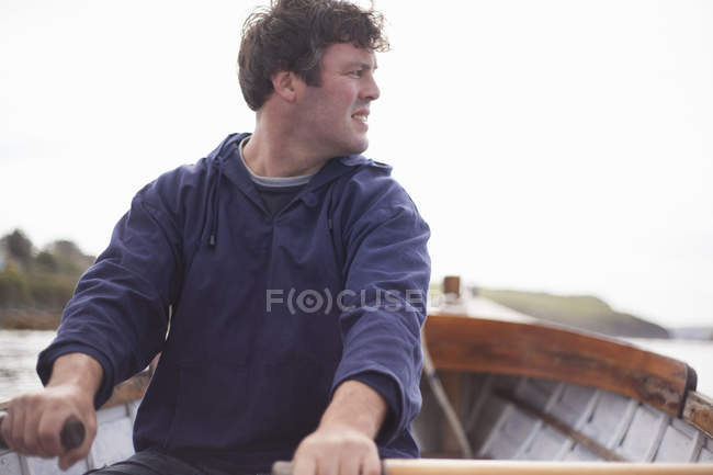 Retrato del hombre remando en barco, Gales, Reino Unido - foto de stock