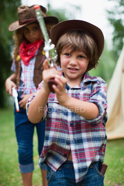 Boy in cowboy hat with toy pistol — Stock Photo