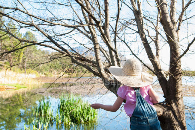 Девушка играет на дереве на открытом воздухе — стоковое фото