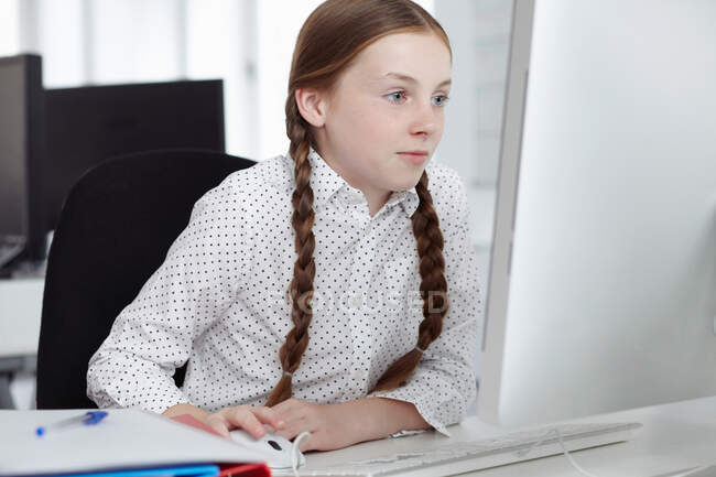 Девушка за компьютером в офисе — стоковое фото