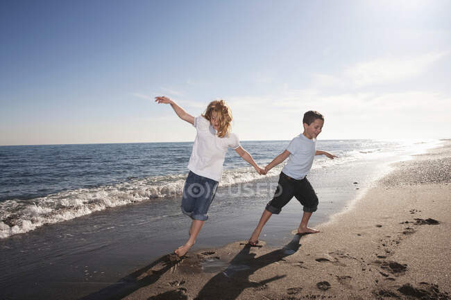 Хлопчик і дівчинка біжать на пляжі — стокове фото