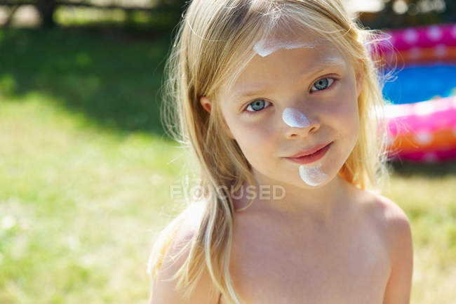 Girl with sunscreen cream on her face — Stock Photo