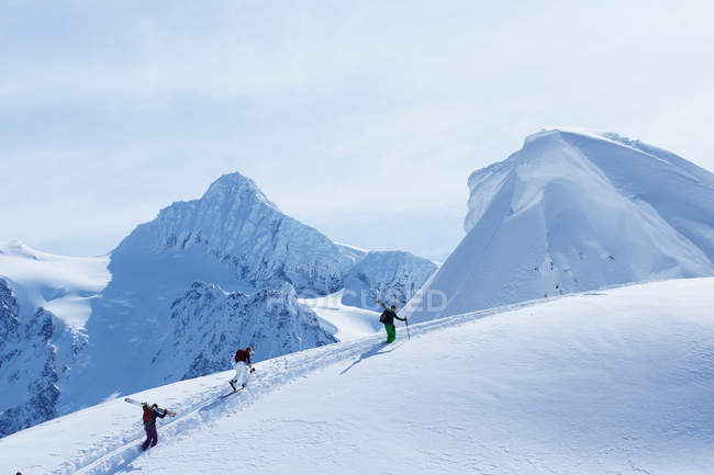 Skiers climbing snowy slope — Stock Photo