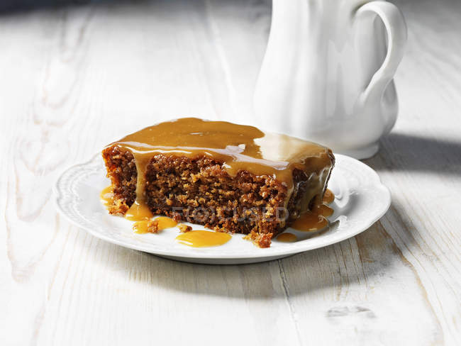 Sticky toffee pudding on white plate — Stock Photo