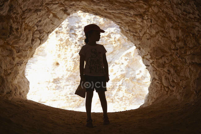 Girl standing in entrance of cave, Cabo de Gata, Almeria, Spain — Stock Photo