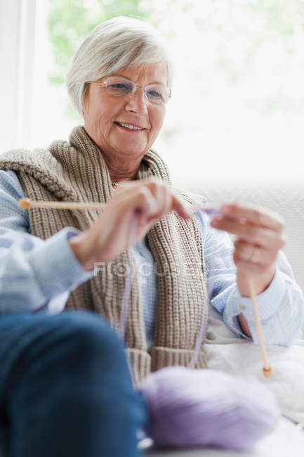 Sorridente donna anziana maglia — Foto stock