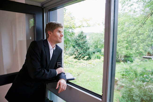 Бизнесмен смотрит в окно офиса — стоковое фото