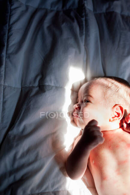 Bebê recém-nascido menino deitado na cama — Fotografia de Stock