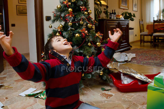 Boy cheering by Christmas tree — Stock Photo