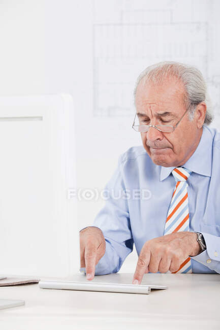 Hombre de negocios superior escribiendo torpemente - foto de stock