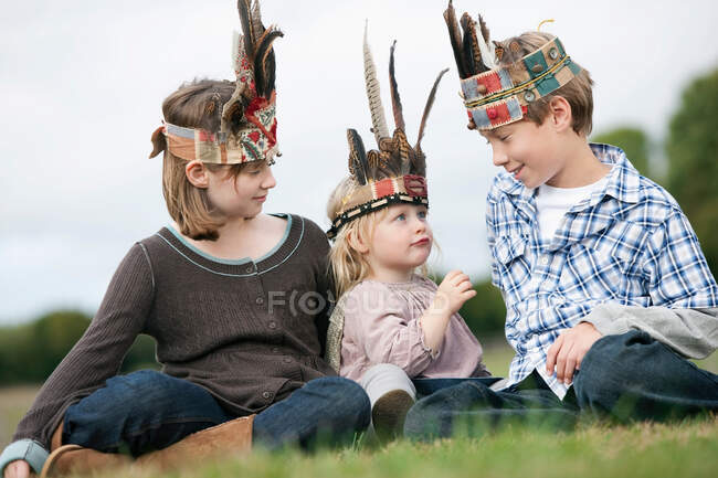 Crianças em chapéus nativos americanos — Fotografia de Stock