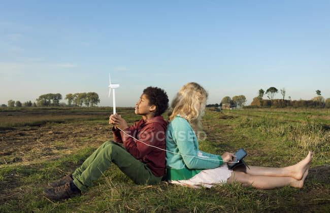 Niños usando turbina eólica miniatura para alimentar tabletas digitales, Breda, Países Bajos - foto de stock
