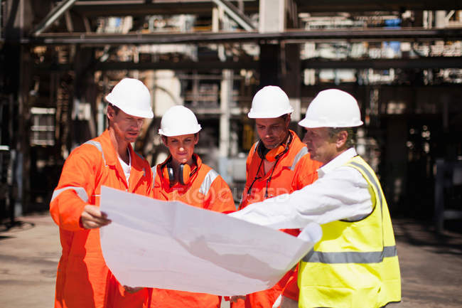 Lavoratori con progetti presso la raffineria di petrolio — Foto stock