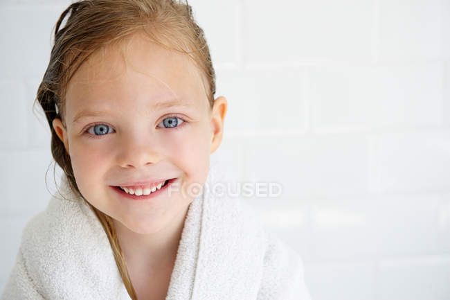 Chica en una toalla de baño, mirando a la cámara - foto de stock