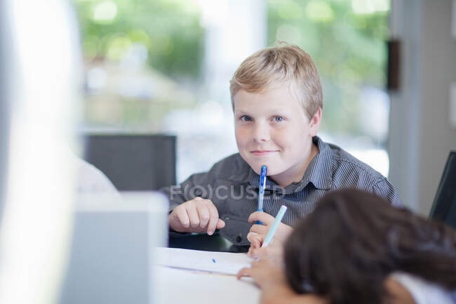 Мальчик играет бизнесмена за столом — стоковое фото