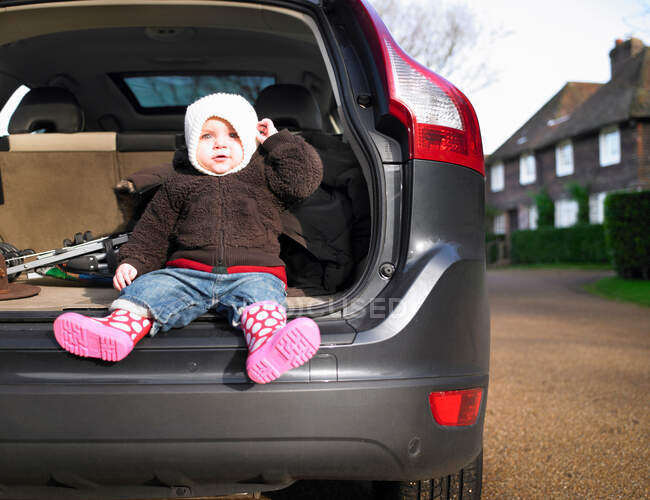 Baby sitzt im offenen Kofferraum — Stockfoto