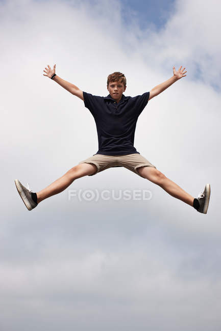 Adolescent garçon posant dans mi-air — Photo de stock