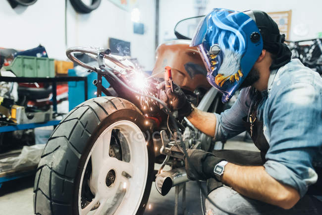 Maduro homem, trabalhando em motocicleta na garagem — Fotografia de Stock
