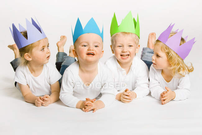 Niños pequeños con coronas de papel - foto de stock