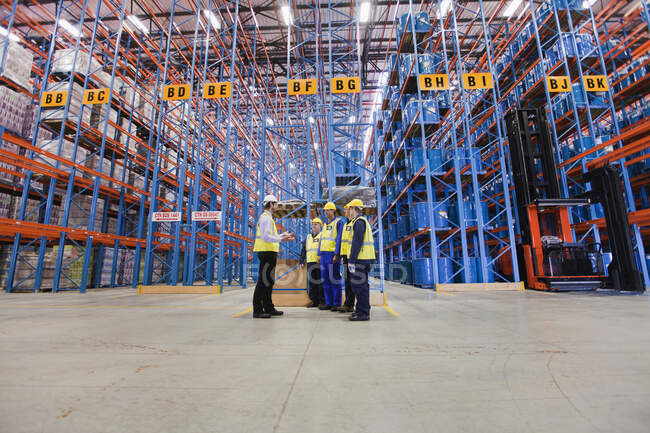 Travailleurs parlant dans un entrepôt — Photo de stock